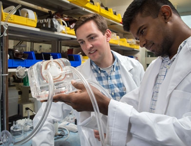 Two male researchers in a lab discuss their work